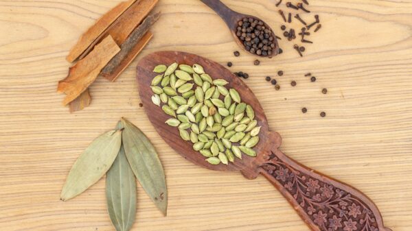 a wooden spoon filled with seeds on top of a wooden table